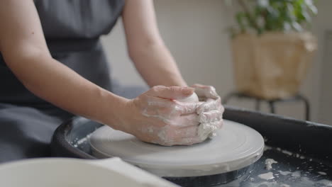 Close-up-of-the-hand-of-a-grumpy-woman-master-works-on-a-potter's-wheel-in-slow-motion.-Making-utensils-with-your-own-hands